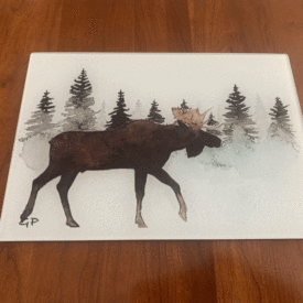 Moose in pine trees cutting board