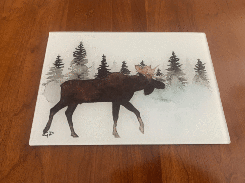 Moose in pine trees cutting board